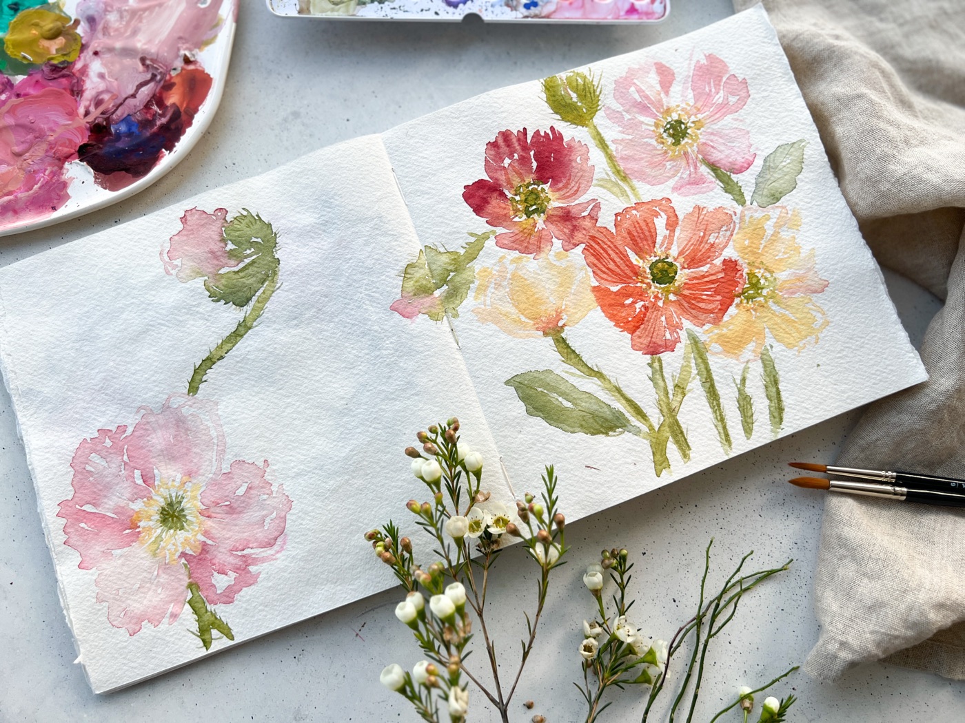 Aquarell bunter Blumen im aufgeschlagenen Skizzenbuch