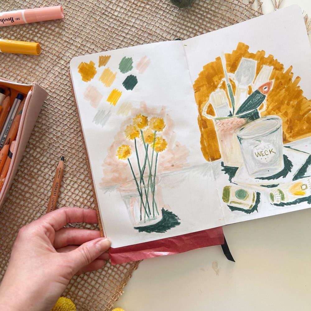 Skizzenbuch mit gemalten Narzissen und Farbpalette