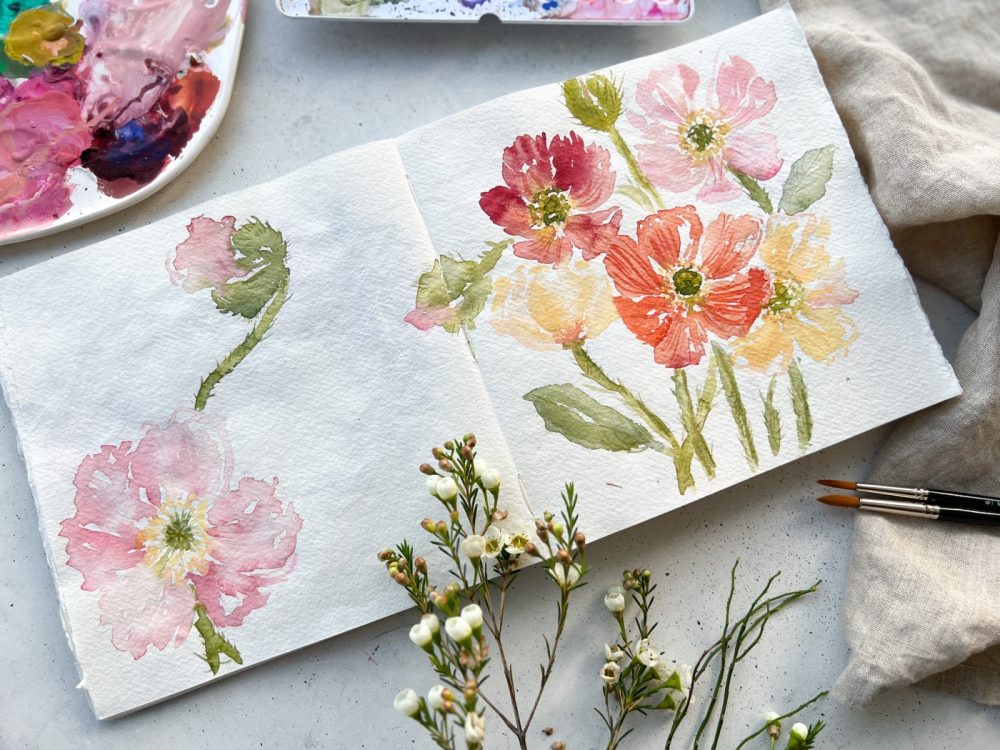 Aquarell bunter Blumen im aufgeschlagenen Skizzenbuch